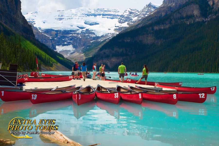 Lake Louise with the unbelievable blue waters and the red boats with people on the dock.