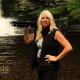Pamela Goodyer with her triopod in front of a waterfall on the photo tour learning photography