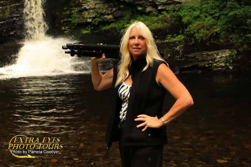 Pamela Goodyer with her triopod in front of a waterfall on the photo tour learning photography